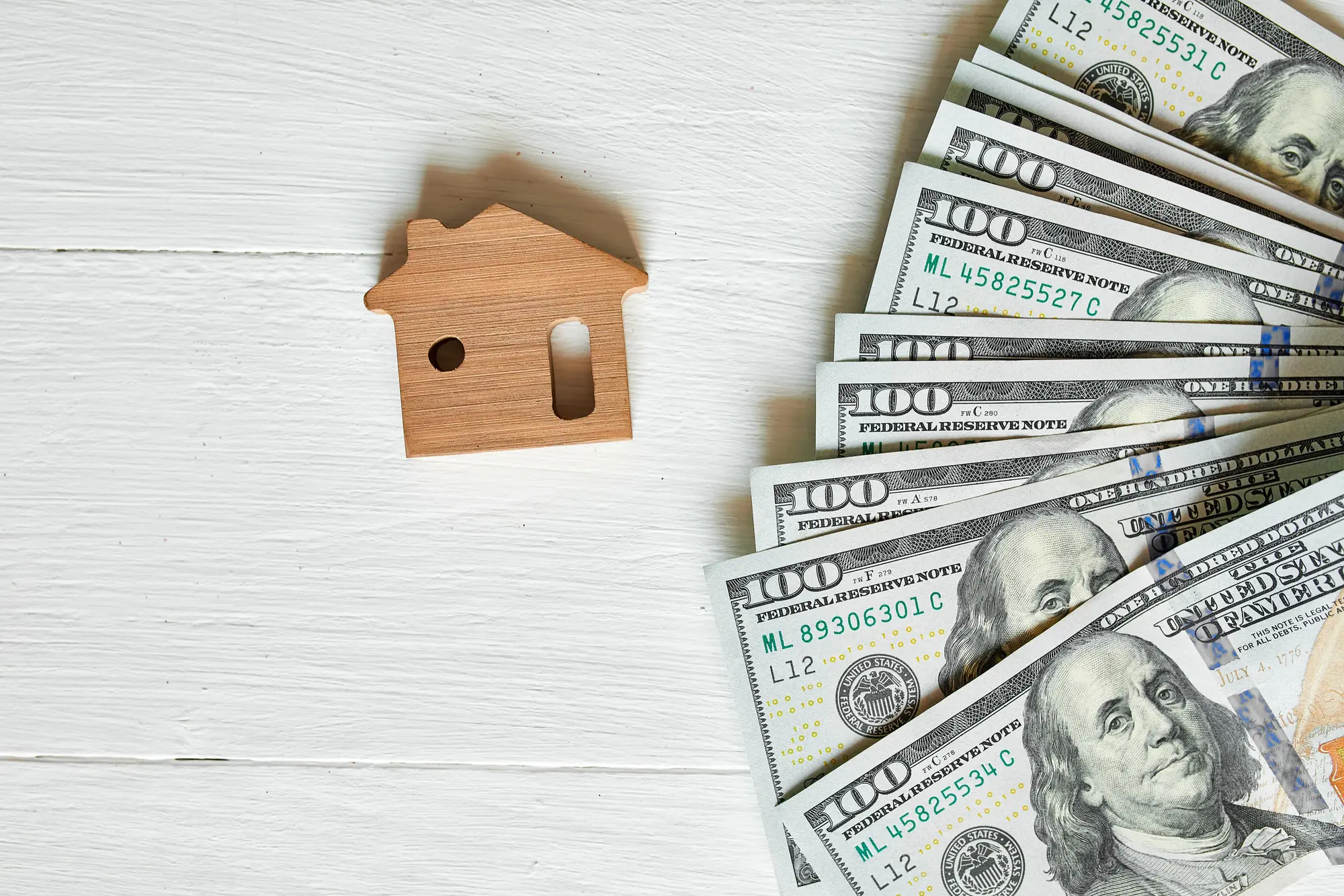 A wooden house with money for HOA fees.